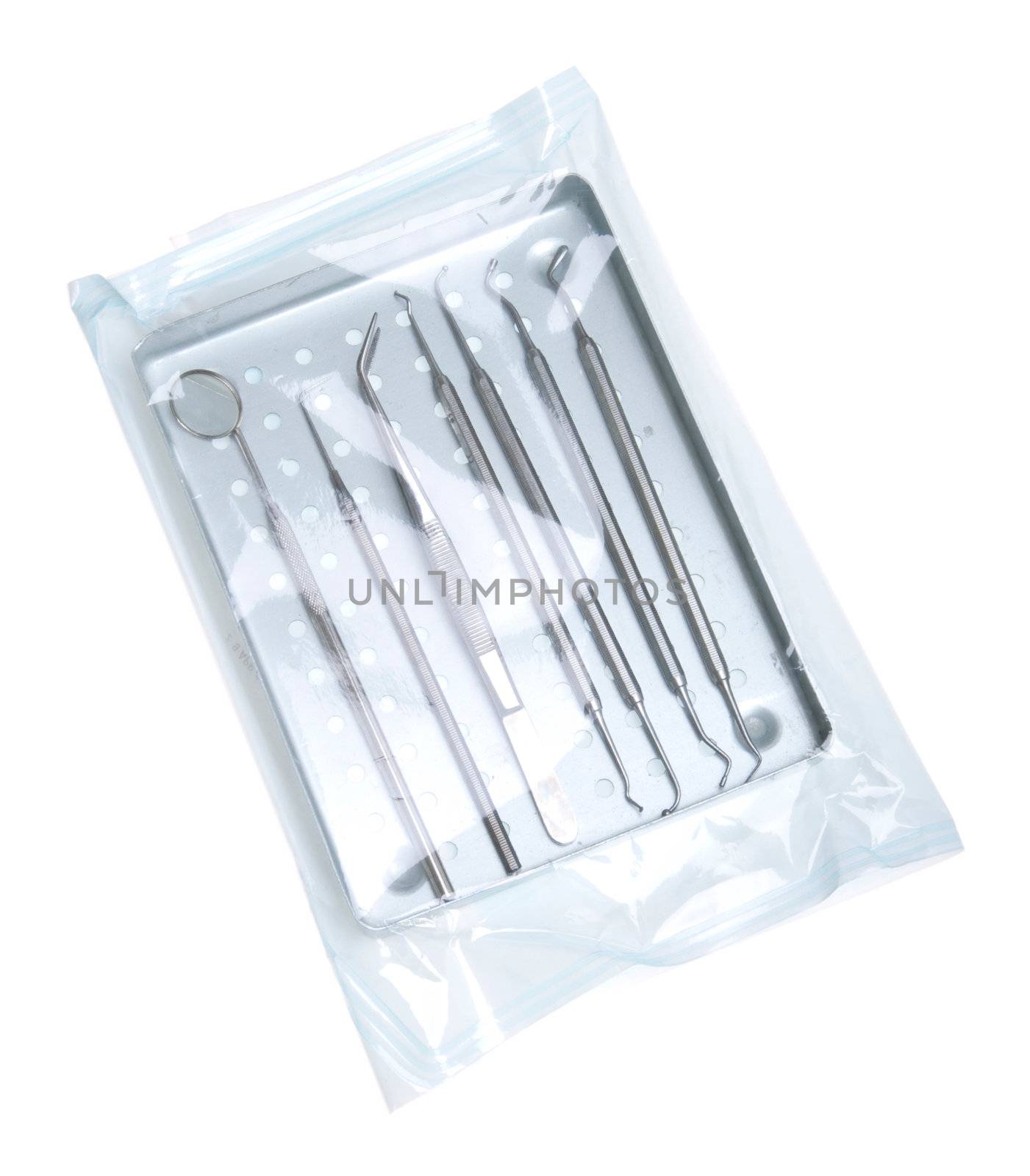dentistry start kit in a tray on a sterilized pouch (isolated on white background)