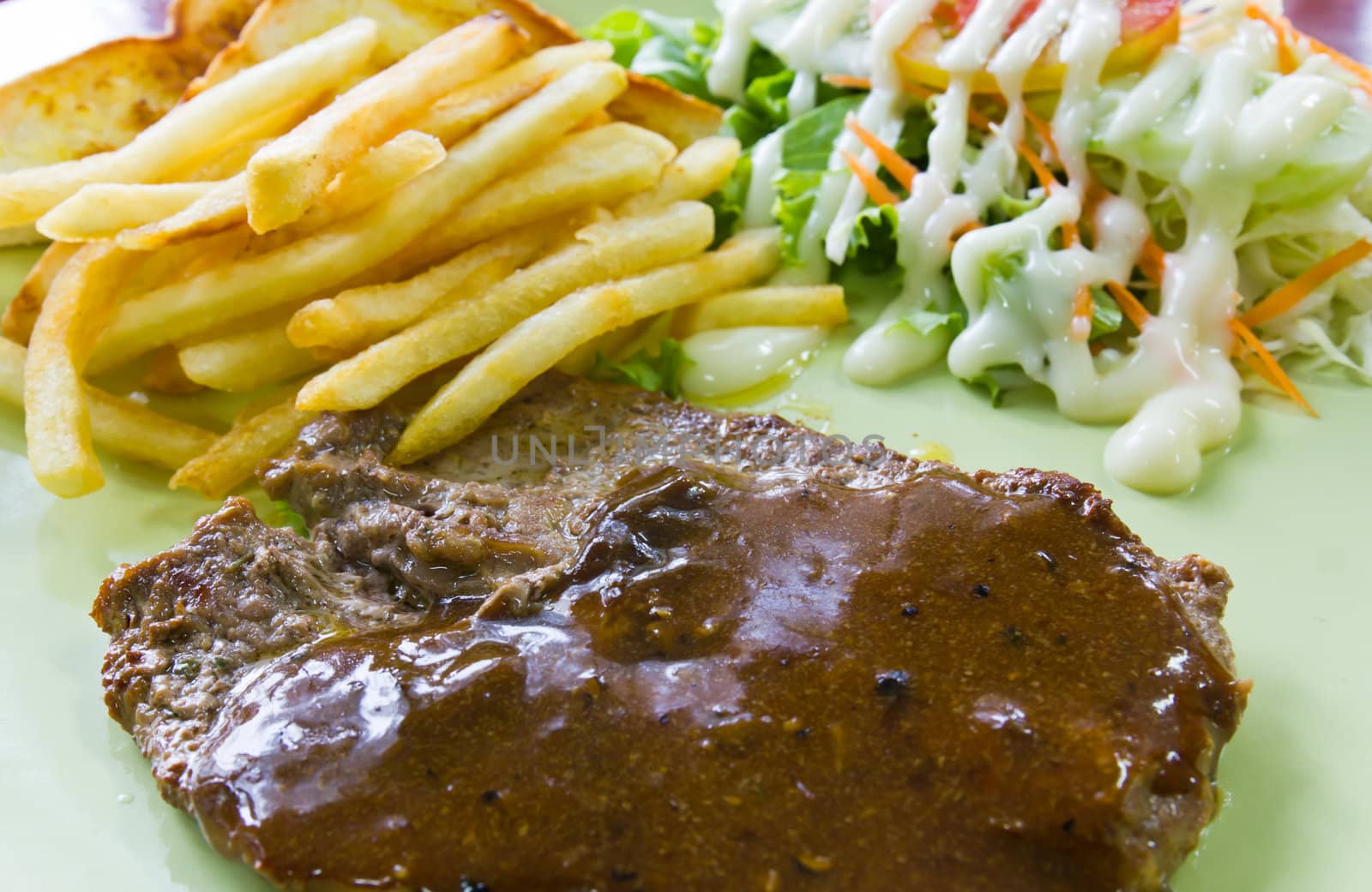 Steak with fresh vegetables salad and french fries