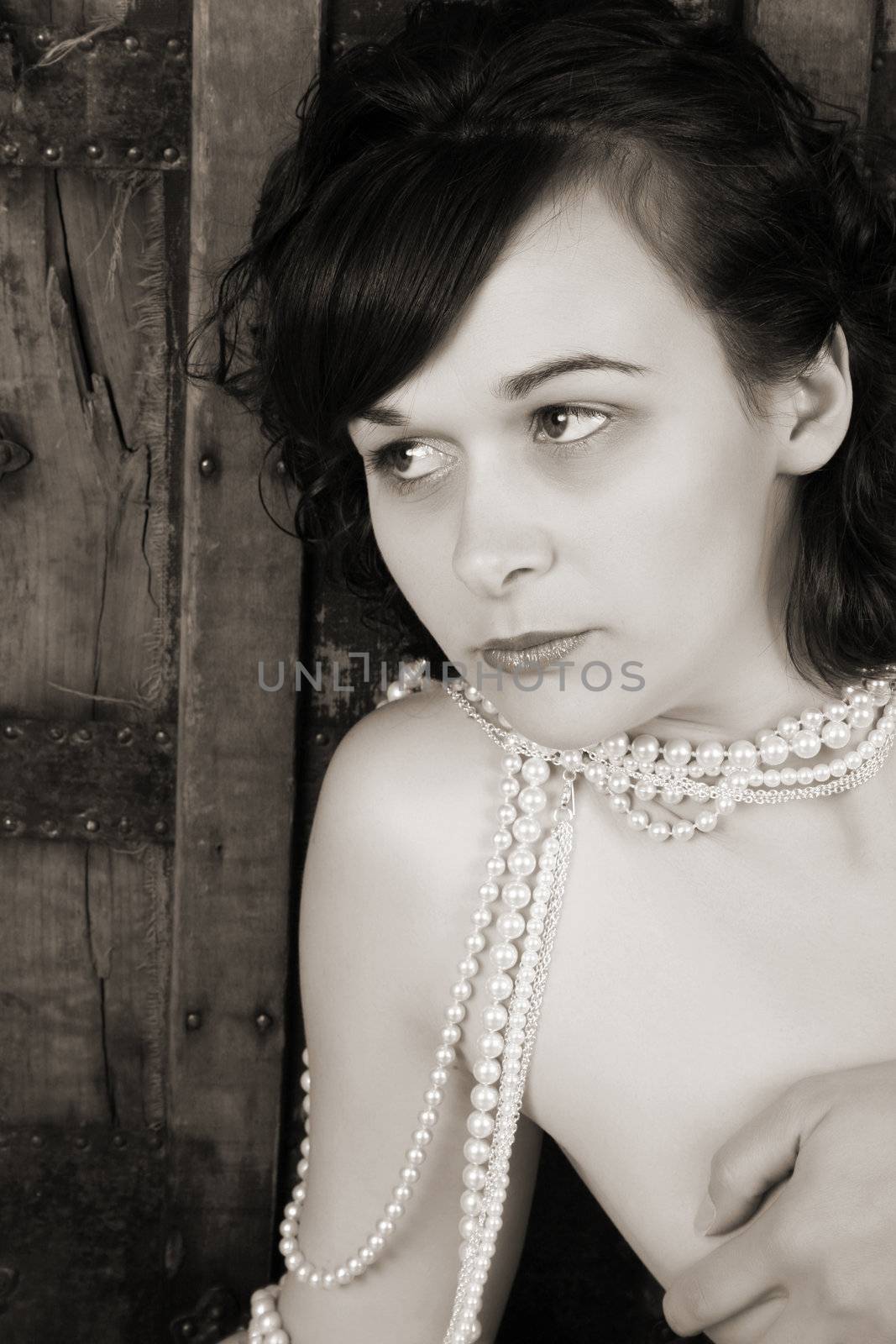 Beautiful brunette against a rugged antique chest with jewelery 
