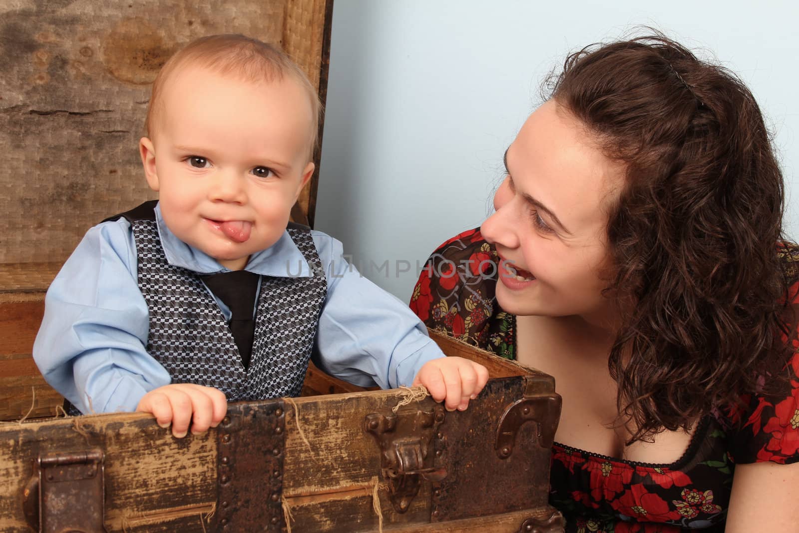 Mother and her baby boy standing inside an antique trunk