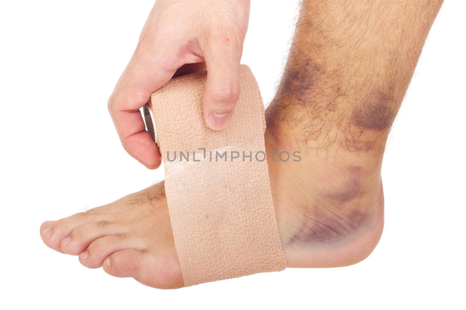 young male with sprained ankle applying medical bandage (isolated on white background)