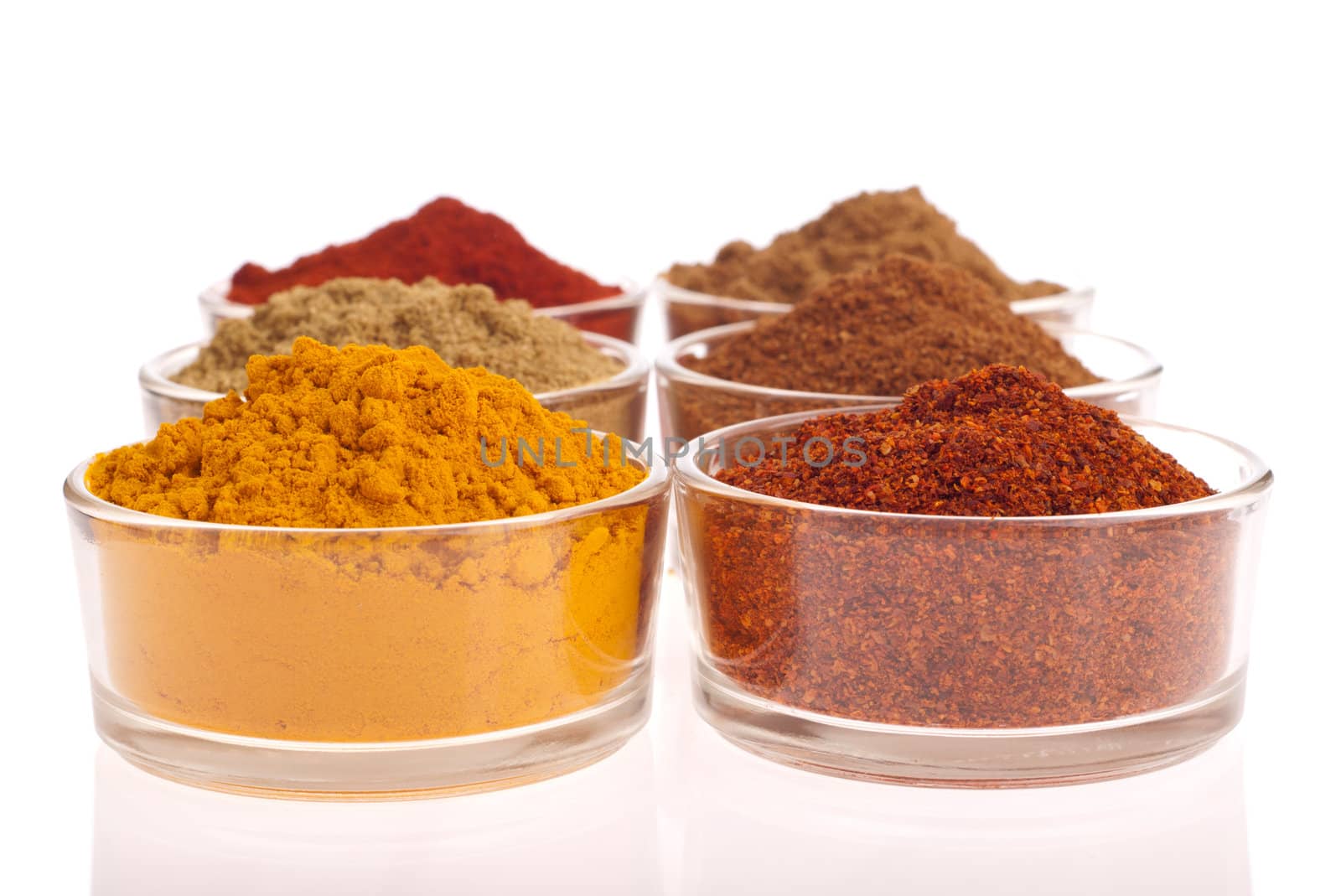 collection of indian spices (cumin, coriander, paprika, garam masala, curcuma, chili powder) on glass cups isolated on white background 