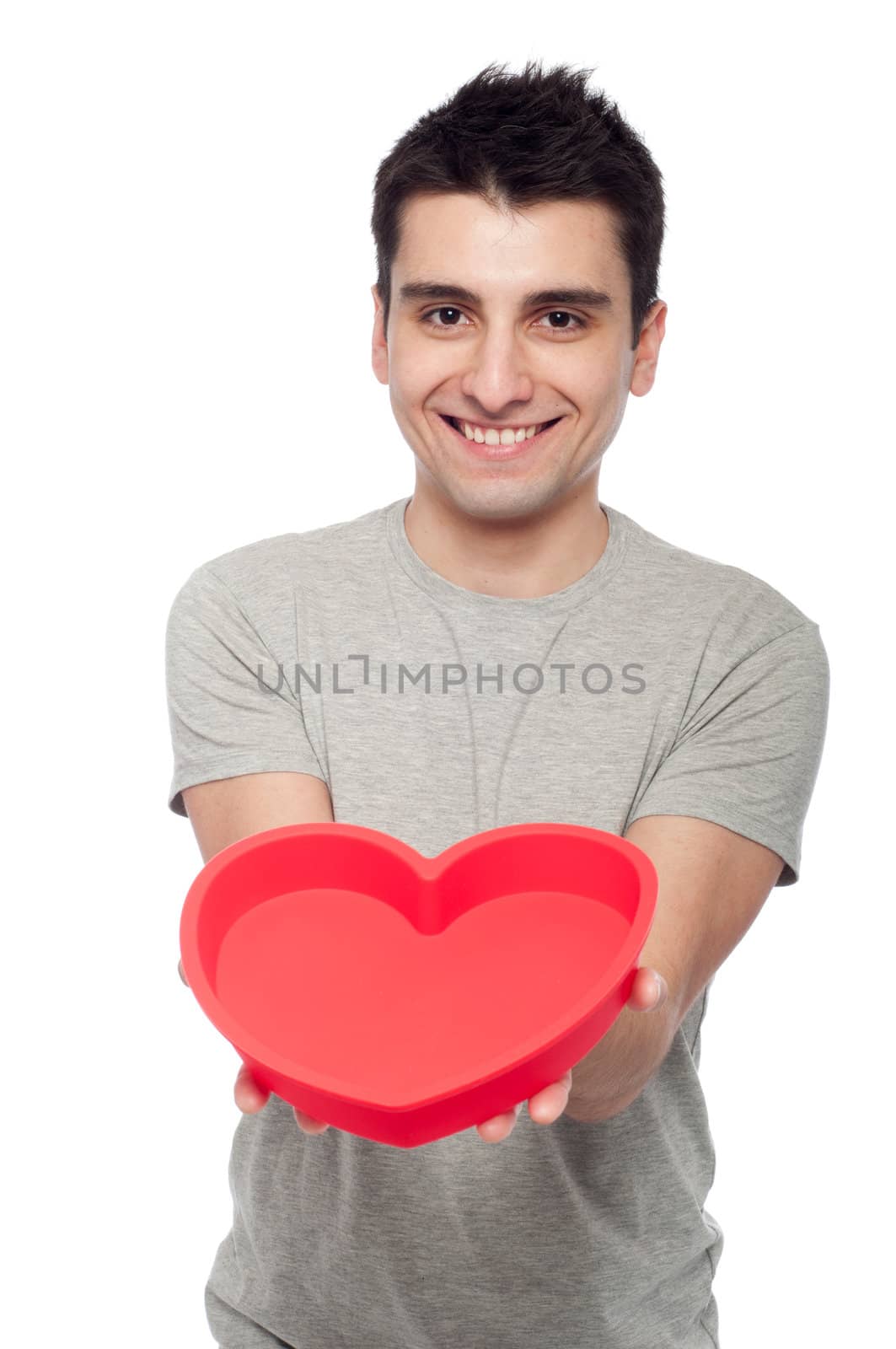 lovely portrait of a young man holding a red heart (isolated on white background)