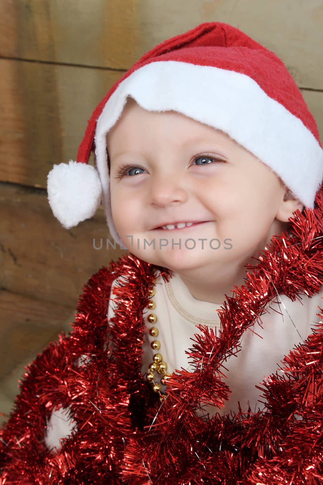 Christmas baby playing with decorations wearing a hat