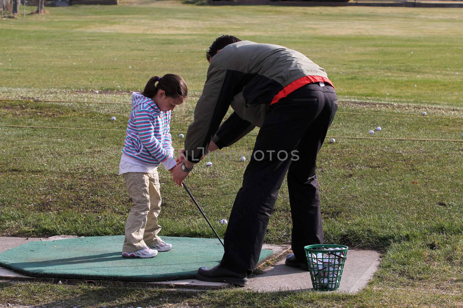 Young female golfer receiving a golf lesson