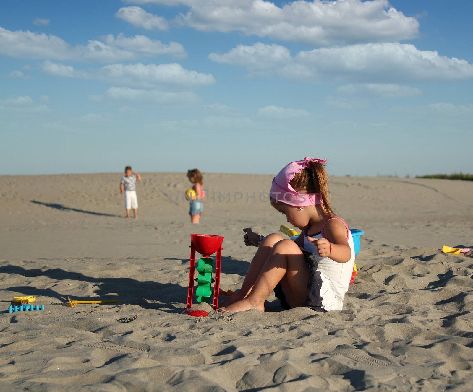 little girl playing with sand by goce