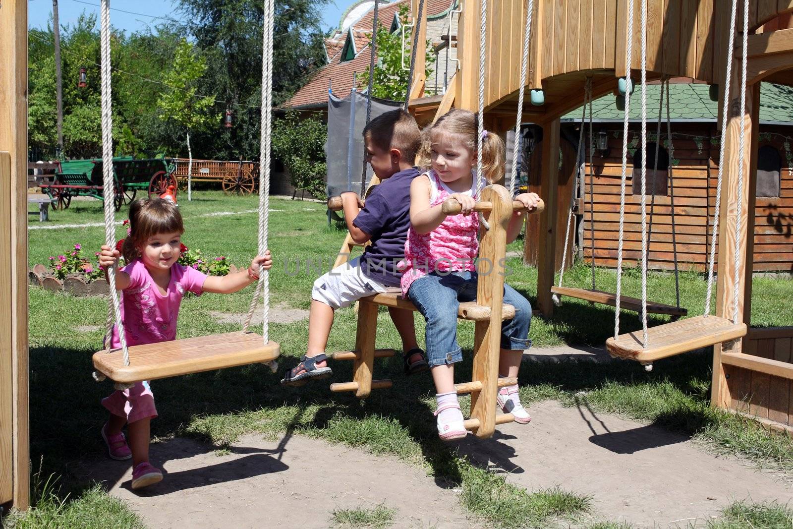 three children on playground by goce