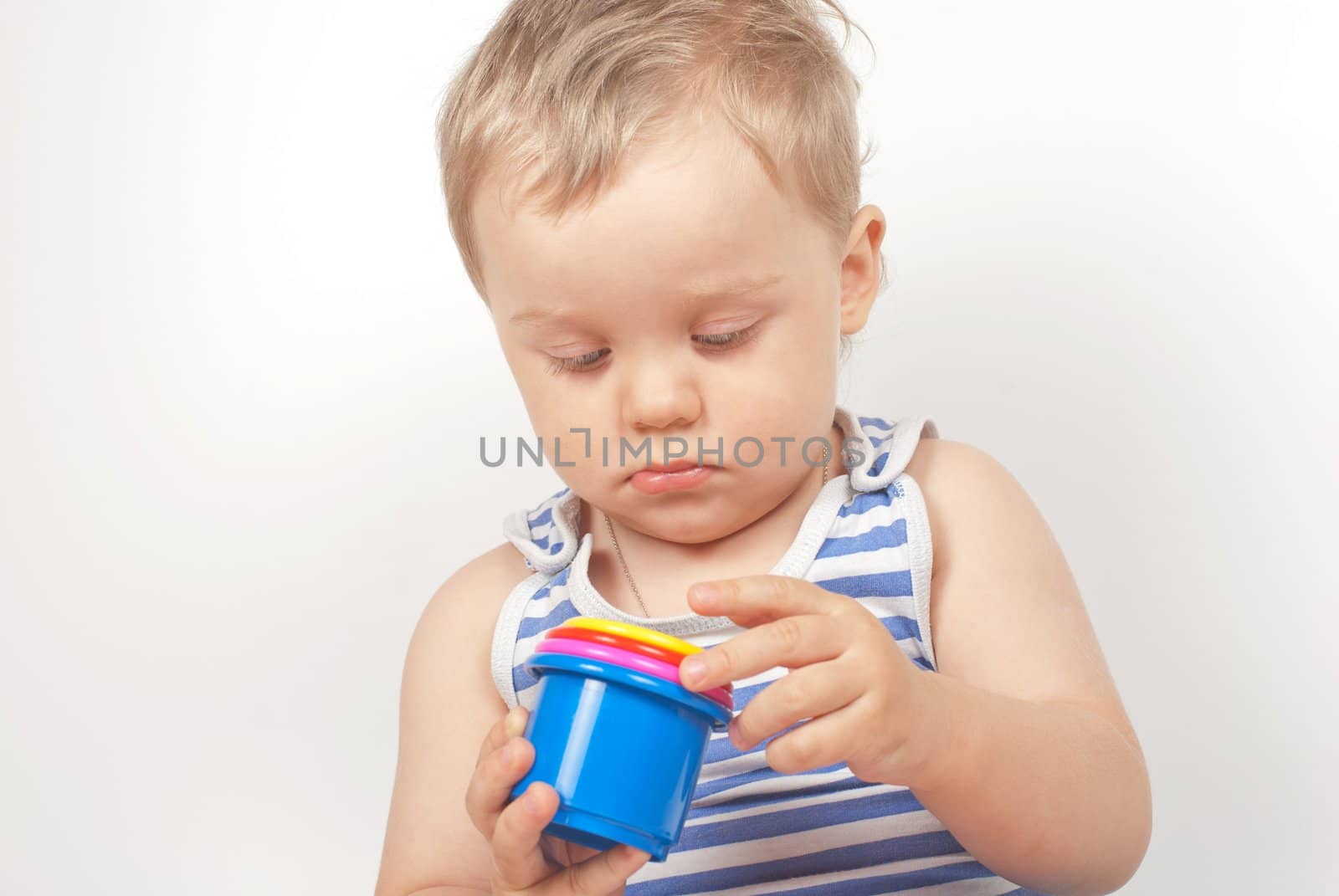 Small baby boy with a toy pyramid isolated on white