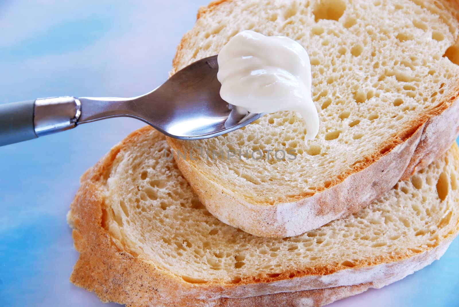 white bread slices with soft butter on spoon closeup