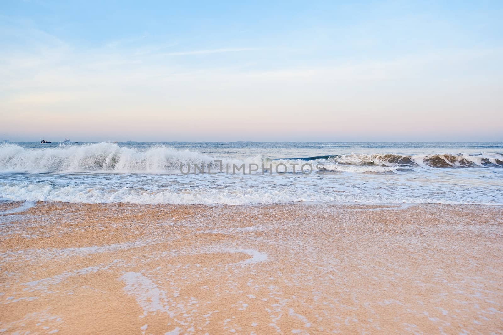 Panoramic view of the wide sandy beach and rolling waves