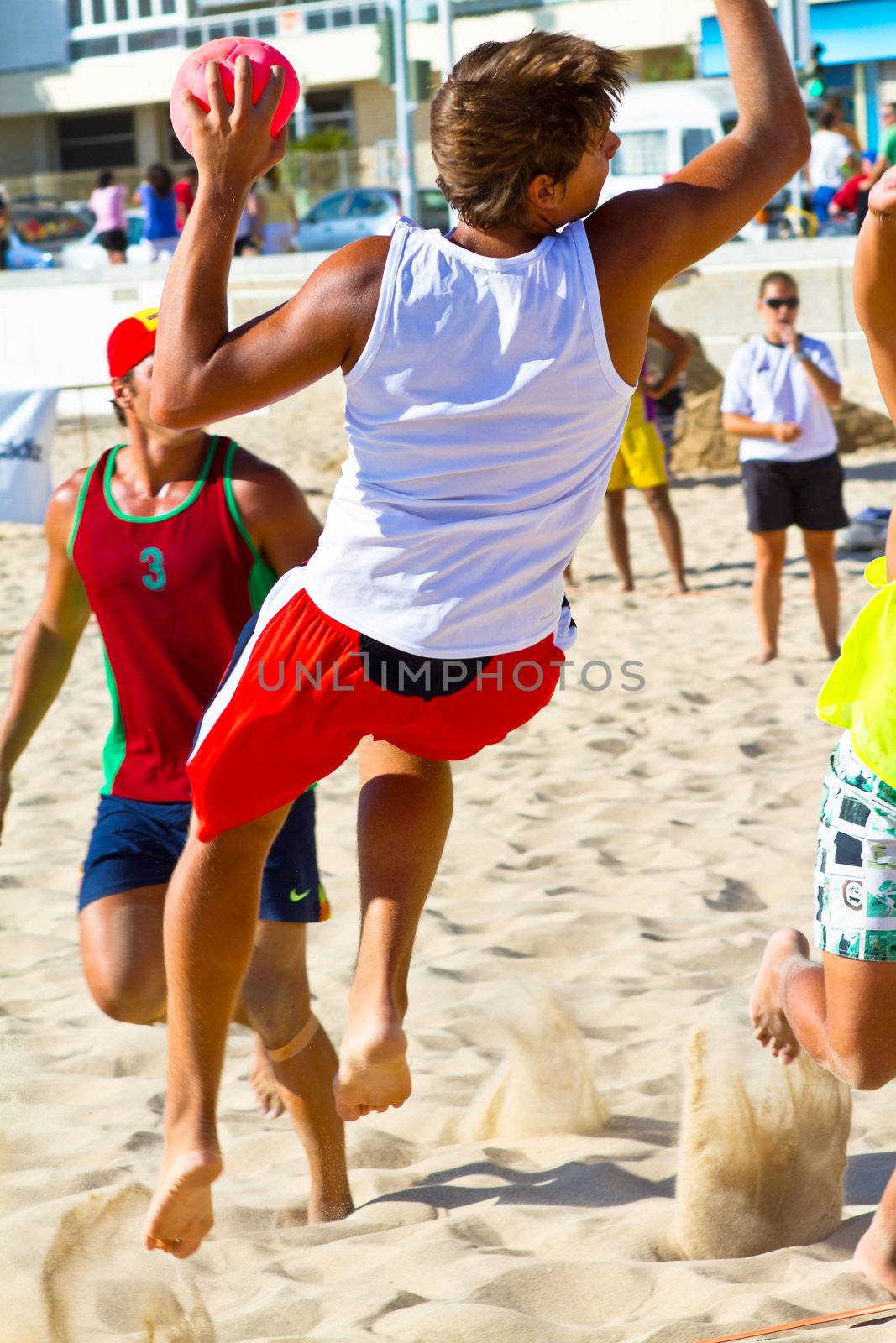 CADIZ, SPAIN - JULY 19: Unidentified players compete in a match between Los Negritos and Ademar Adentro in the 19th league of beach handball of Cadiz on July 19, 2011 in Cadiz, Spain