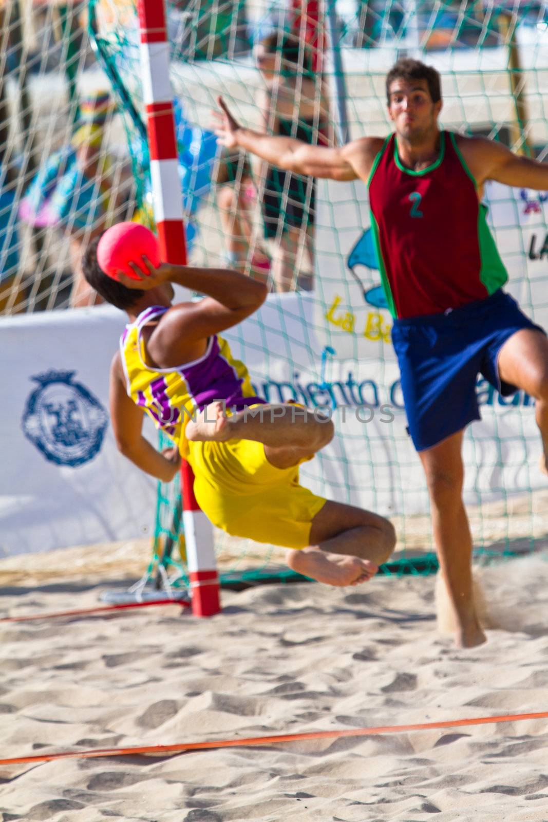 CADIZ, SPAIN - JULY 19: Unidentified players compete in a match between Los Negritos and Ademar Adentro in the 19th league of beach handball of Cadiz on July 19, 2011 in Cadiz, Spain