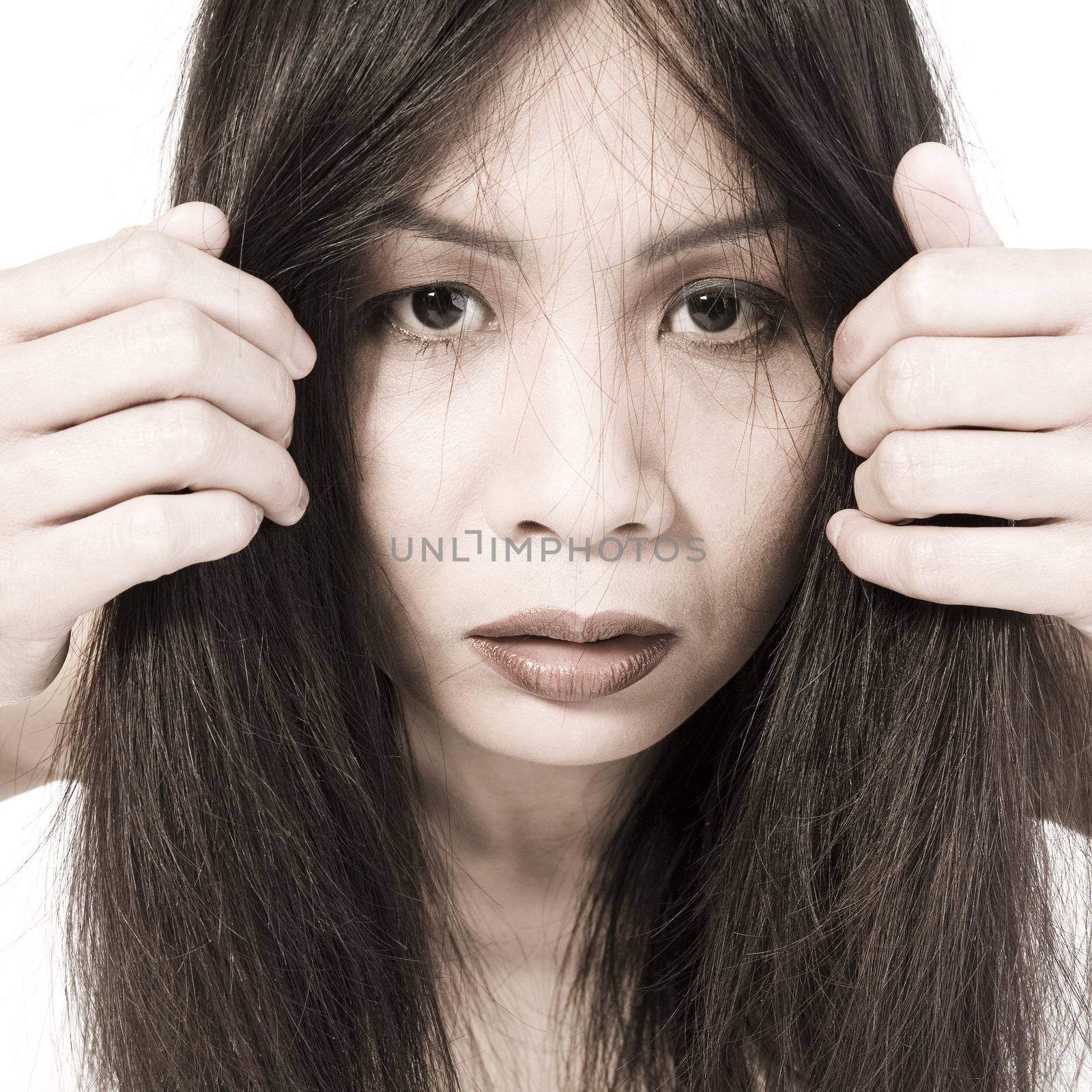 Studio portrait of a asian girl looking through her own hairs