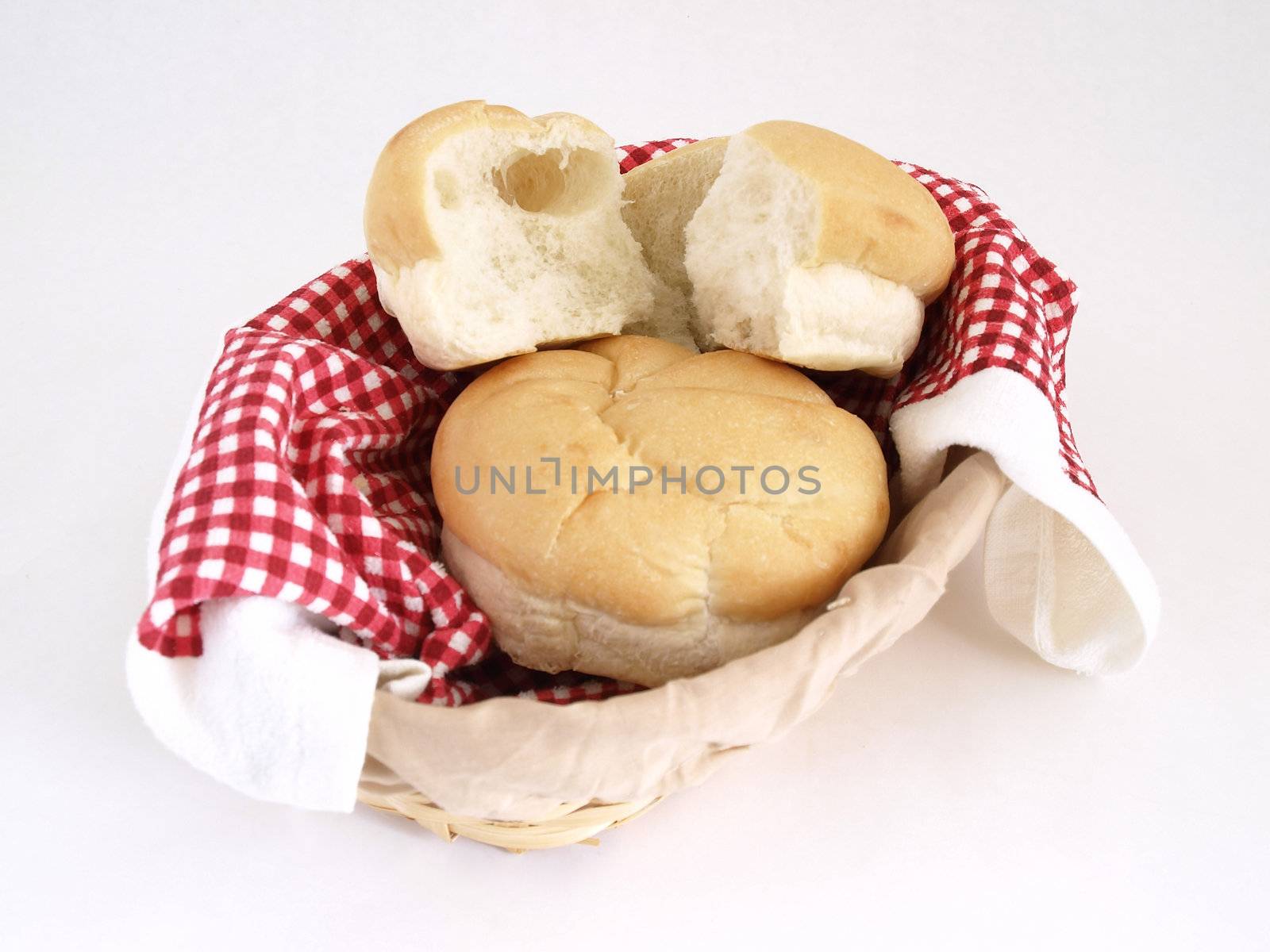 Fresh rolls of bread in a basket. Studio isolated over white.