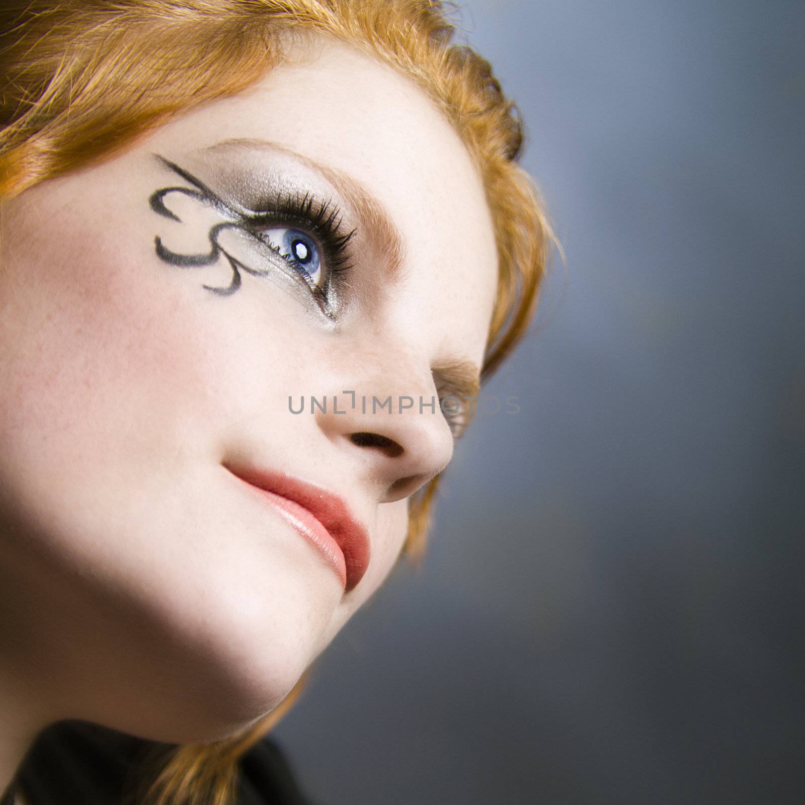 Studio portrait of natural red haired beauty looking up