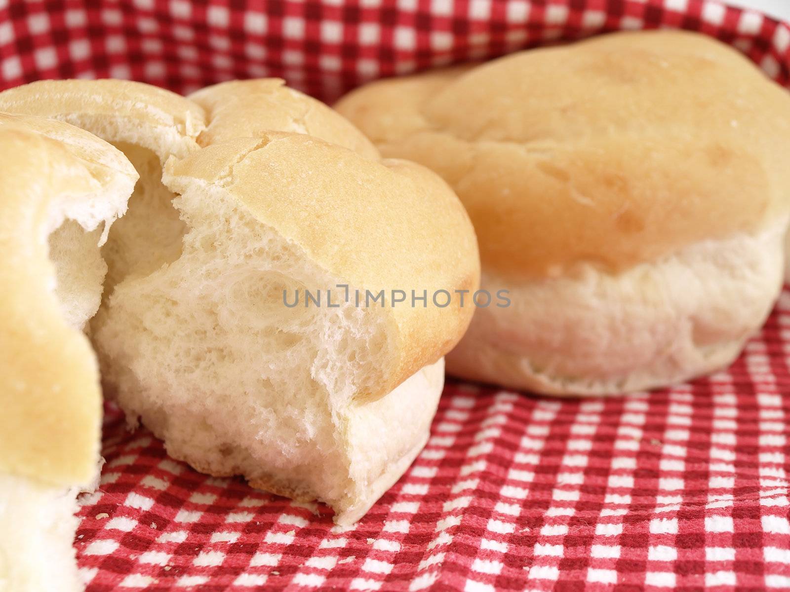 Fresh rolls of bread in a basket. Studio isolated over white.