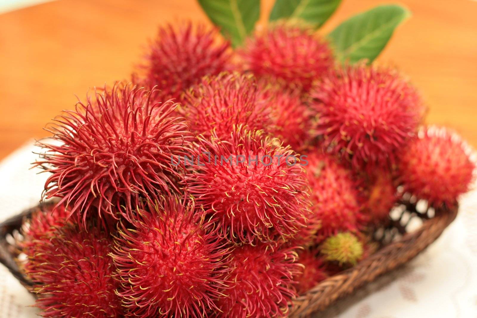 a tray of red hairy rambutan fruits
