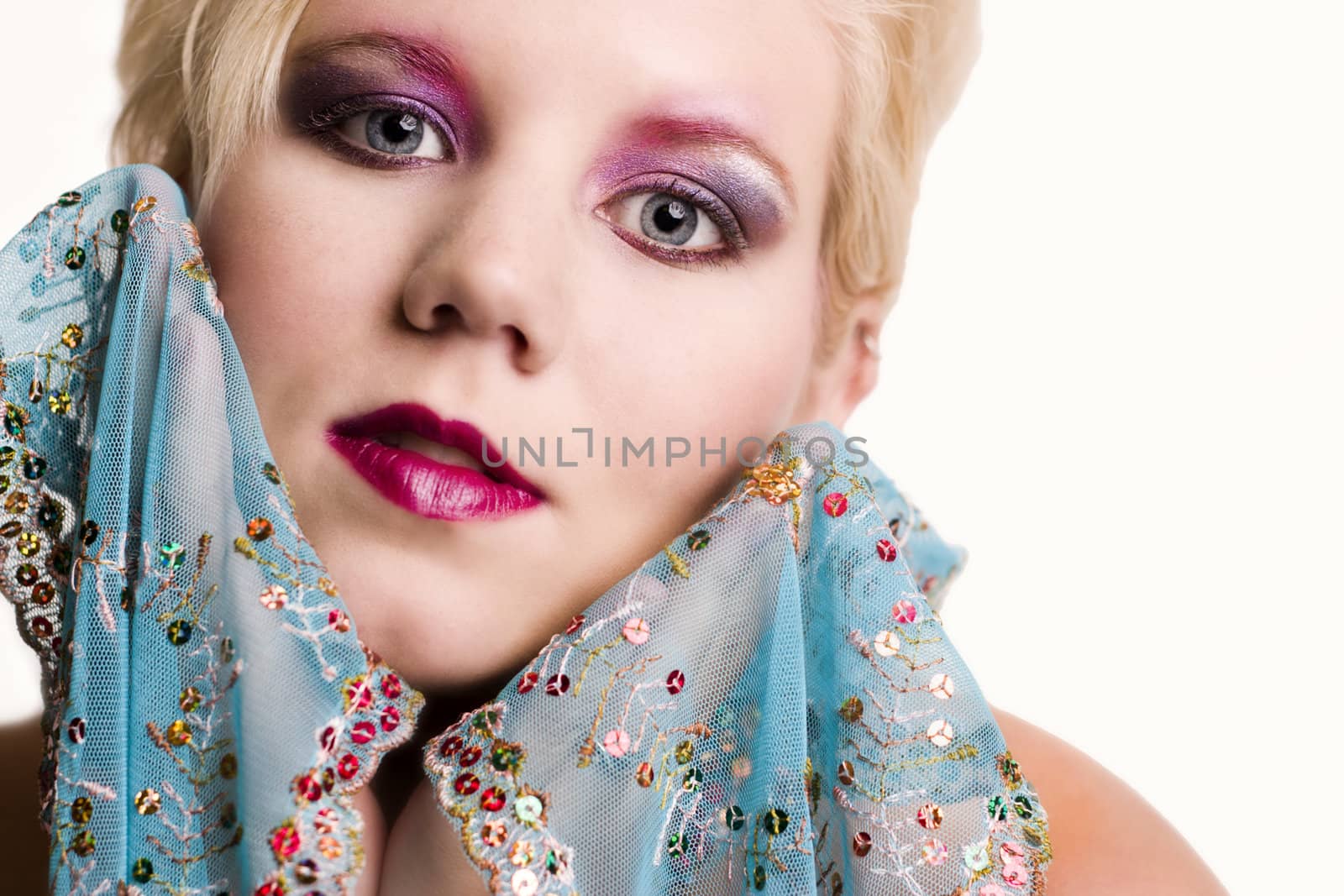 Studio portrait of a blond young lady with a silk scarf