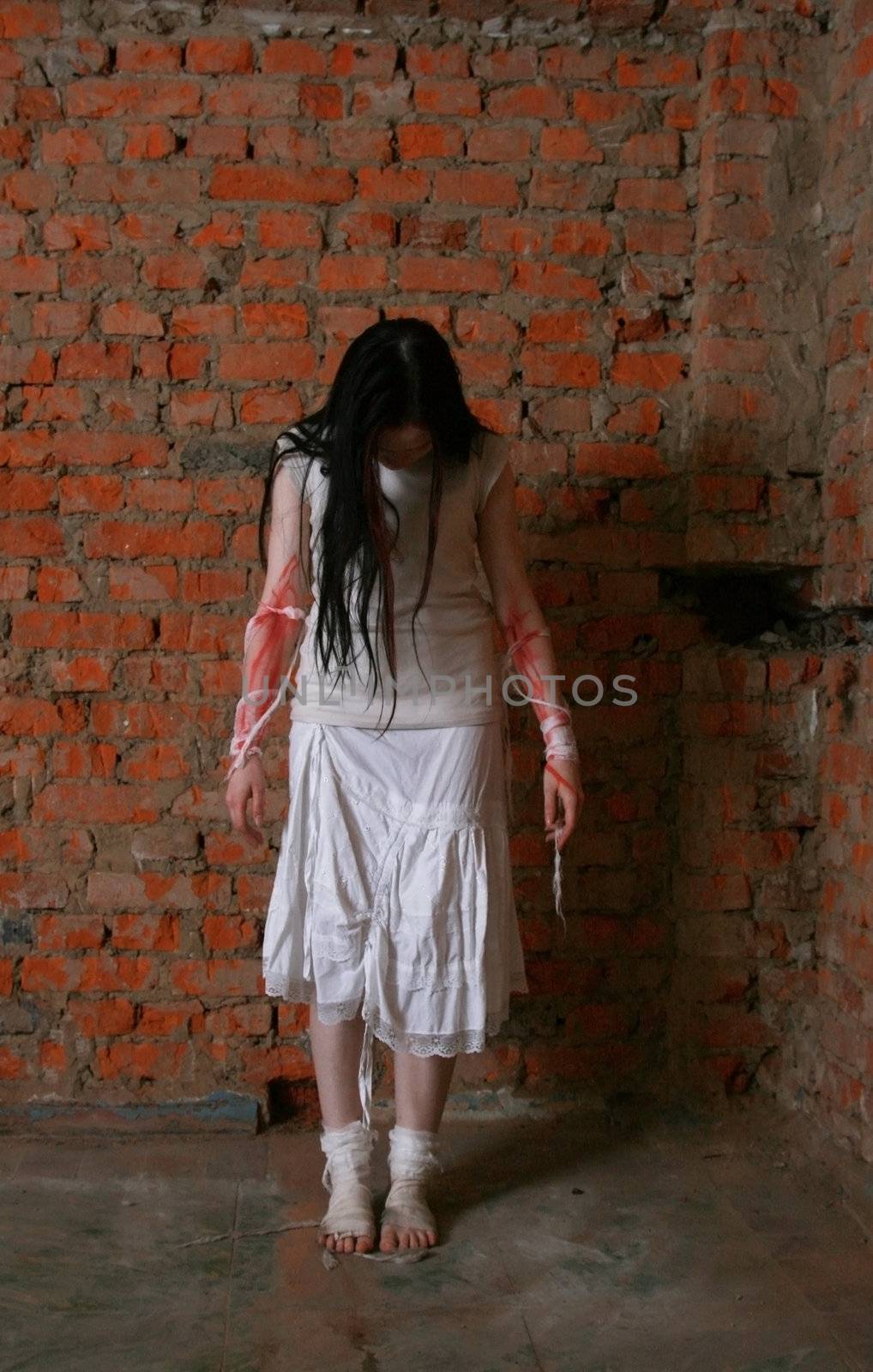 The young girl in a brick cellar with the stained with blood hands