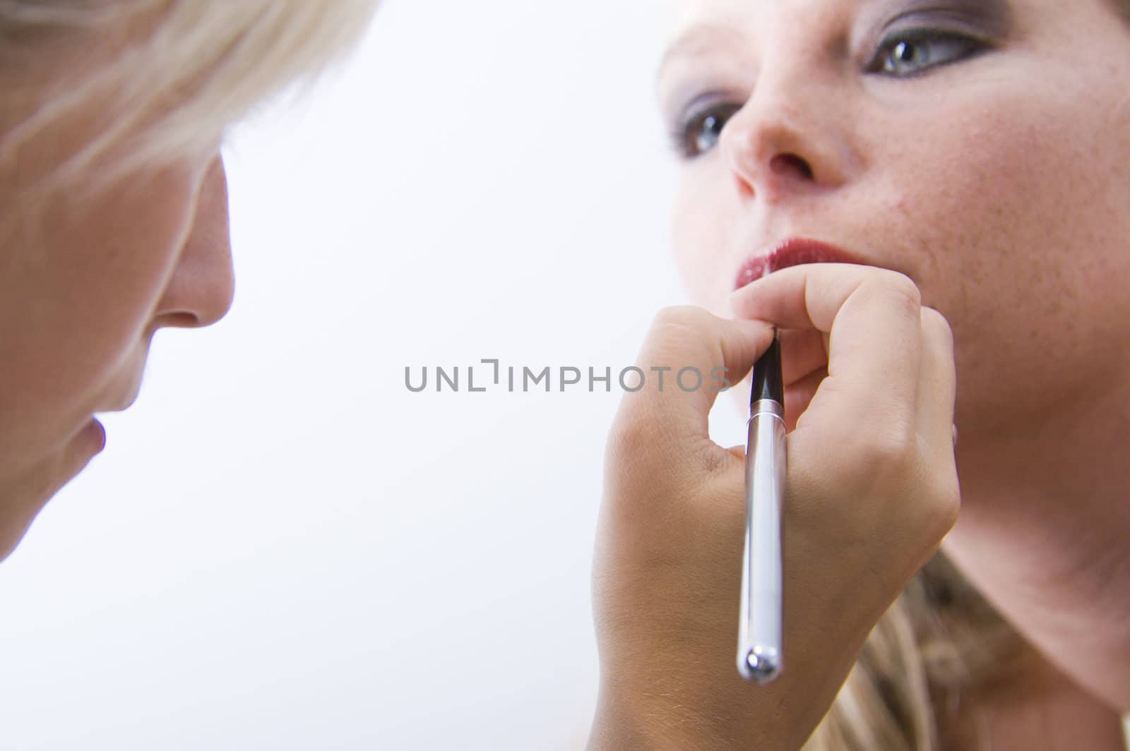 Studio portrait of a beautyfull blond model with her make-up artist