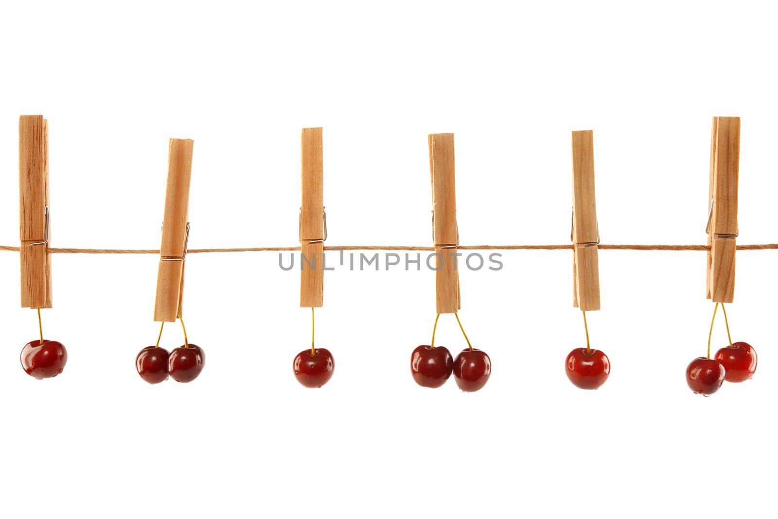 Sweet red cherries and clothes line isolated on a white background