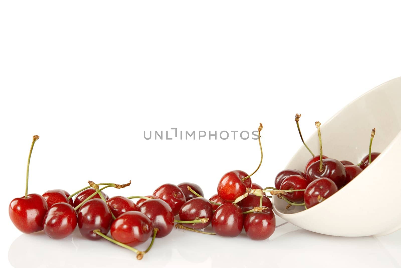Sweet red cherries and ceramic bowl isolated on a white background
