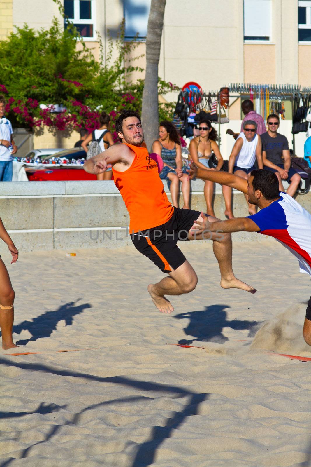 CADIZ, SPAIN - JULY 19: Unidentified players compete in a match between Los Negritos and Autoescuela Barquin in the 19th league of beach handball of Cadiz on July 19, 2011 in Cadiz, Spain