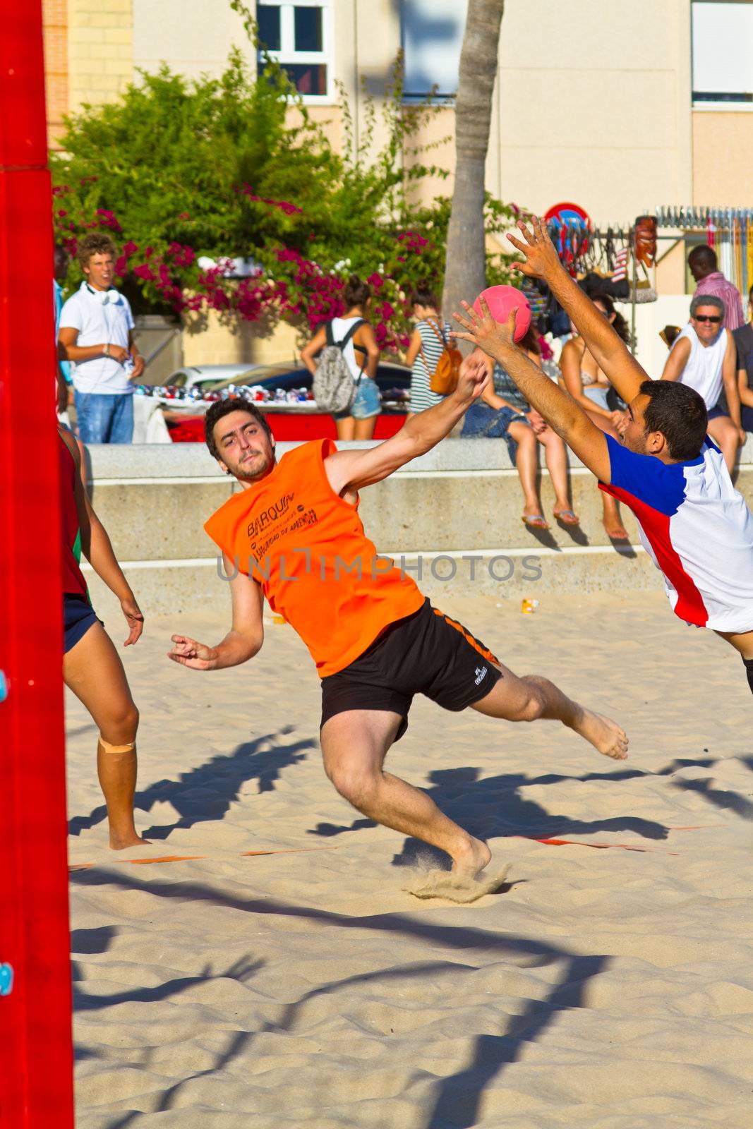 CADIZ, SPAIN - JULY 19: Unidentified players compete in a match between Los Negritos and Autoescuela Barquin in the 19th league of beach handball of Cadiz on July 19, 2011 in Cadiz, Spain