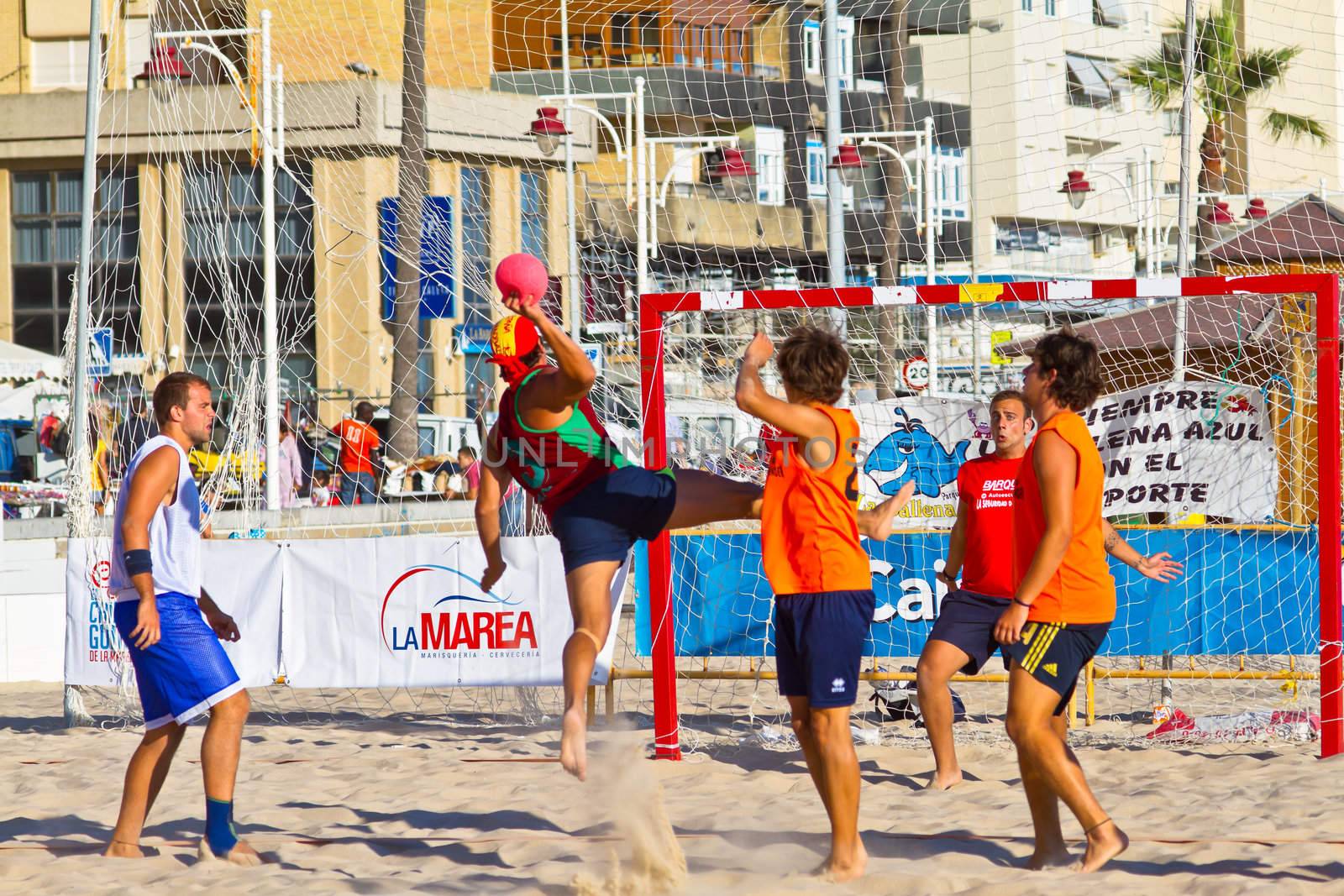CADIZ, SPAIN - JULY 19: Unidentified players compete in a match between Los Negritos and Autoescuela Barquin in the 19th league of beach handball of Cadiz on July 19, 2011 in Cadiz, Spain