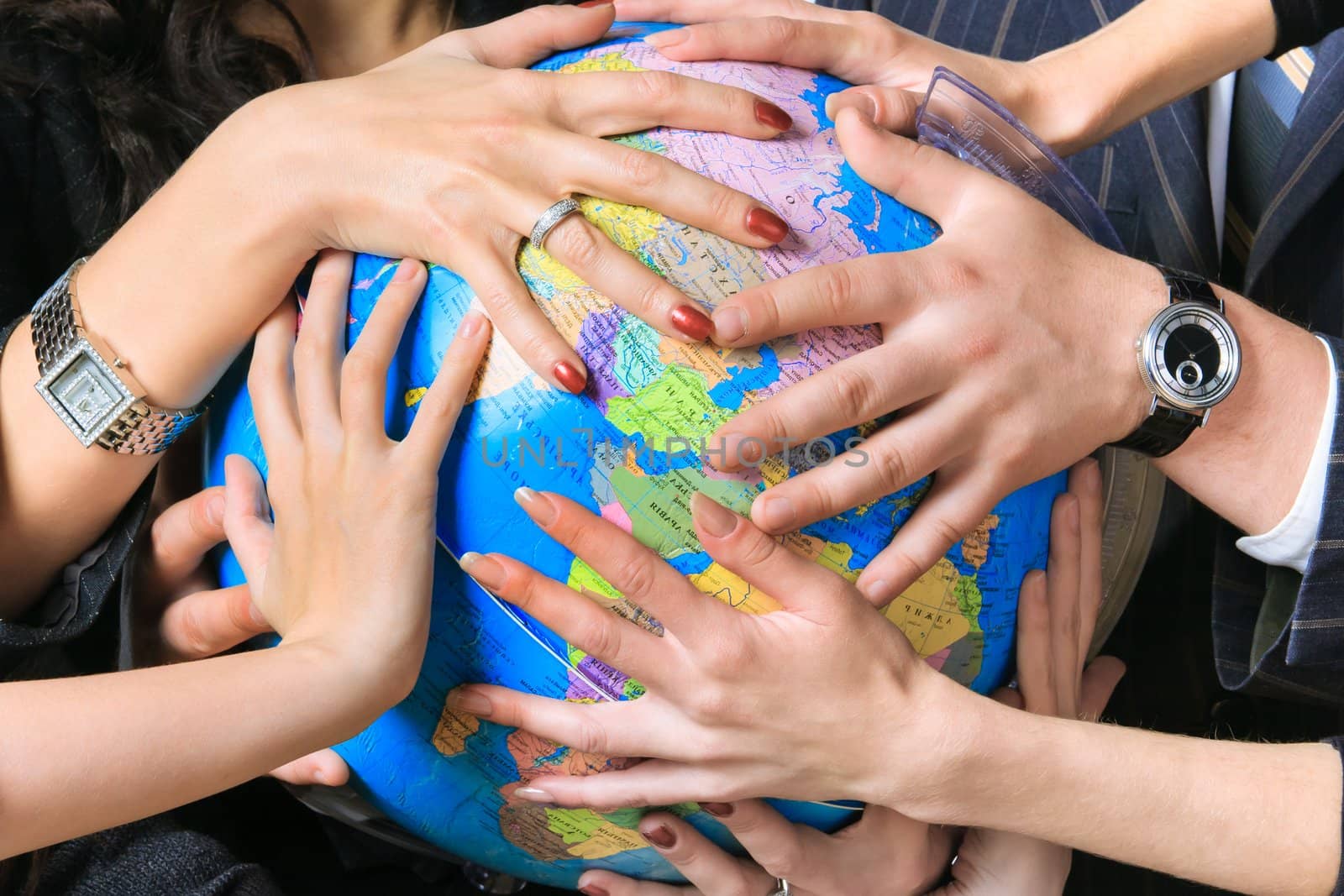 Several different people hold the globe in their hands