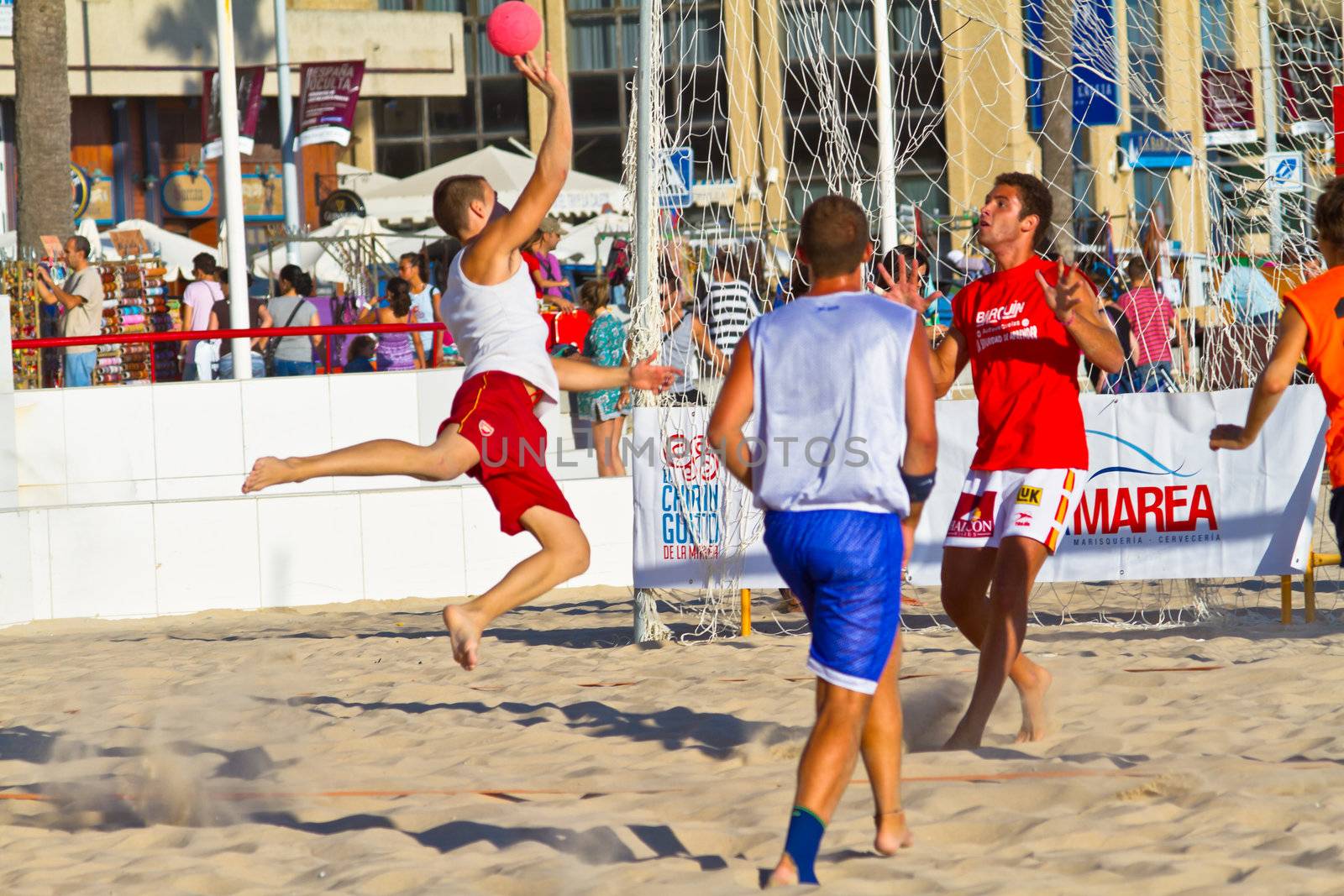 CADIZ, SPAIN - JULY 19: Unidentified players compete in a match between Los Negritos and Autoescuela Barquin in the 19th league of beach handball of Cadiz on July 19, 2011 in Cadiz, Spain
