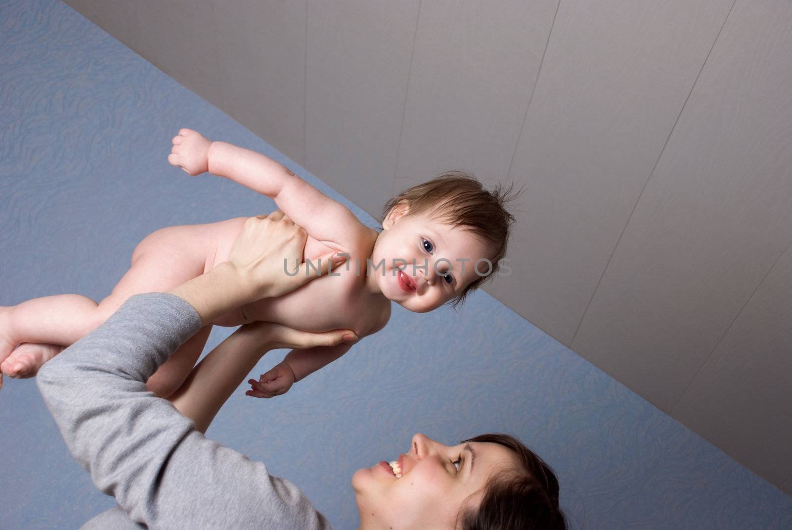 Happy Mother lifts up a tiny, beautiful baby.