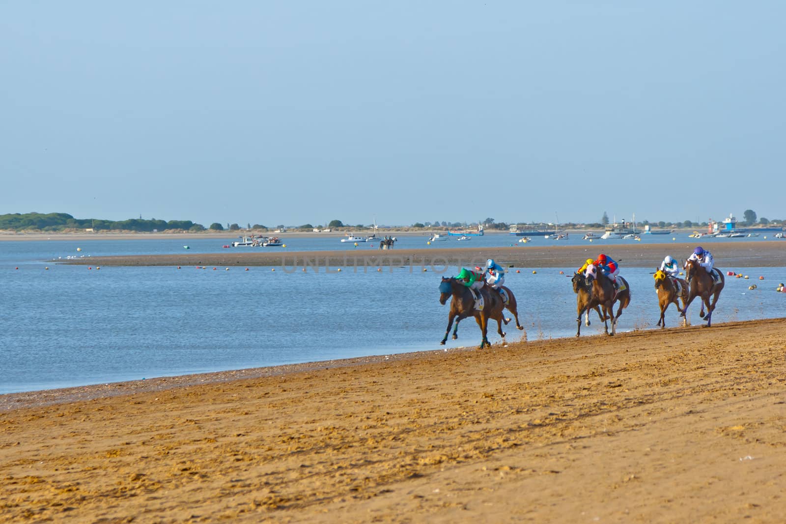 SANLUCAR DE BARRAMEDA, CADIZ, SPAIN - AUGUST 10: Unidentified riders at the start of race horses on Sanlucar de Barrameda beach on August 10, 2011 in Sanlucar de Barrameda, Cadiz, Spain.