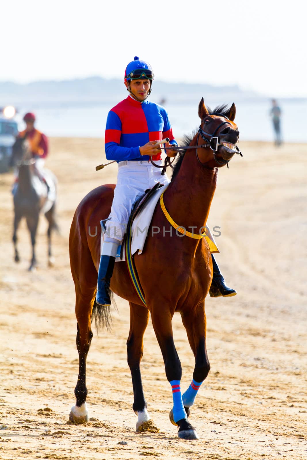SANLUCAR DE BARRAMEDA, CADIZ, SPAIN - AUGUST 10: Unidentified riders at the start of race horses on Sanlucar de Barrameda beach on August 10, 2011 in Sanlucar de Barrameda, Cadiz, Spain.