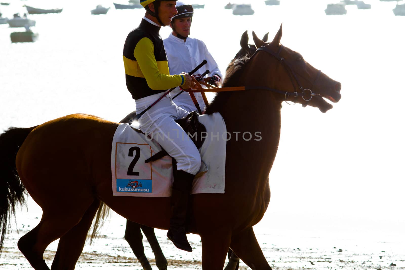 SANLUCAR DE BARRAMEDA, CADIZ, SPAIN - AUGUST 10: Unidentified riders at the start of race horses on Sanlucar de Barrameda beach on August 10, 2011 in Sanlucar de Barrameda, Cadiz, Spain.