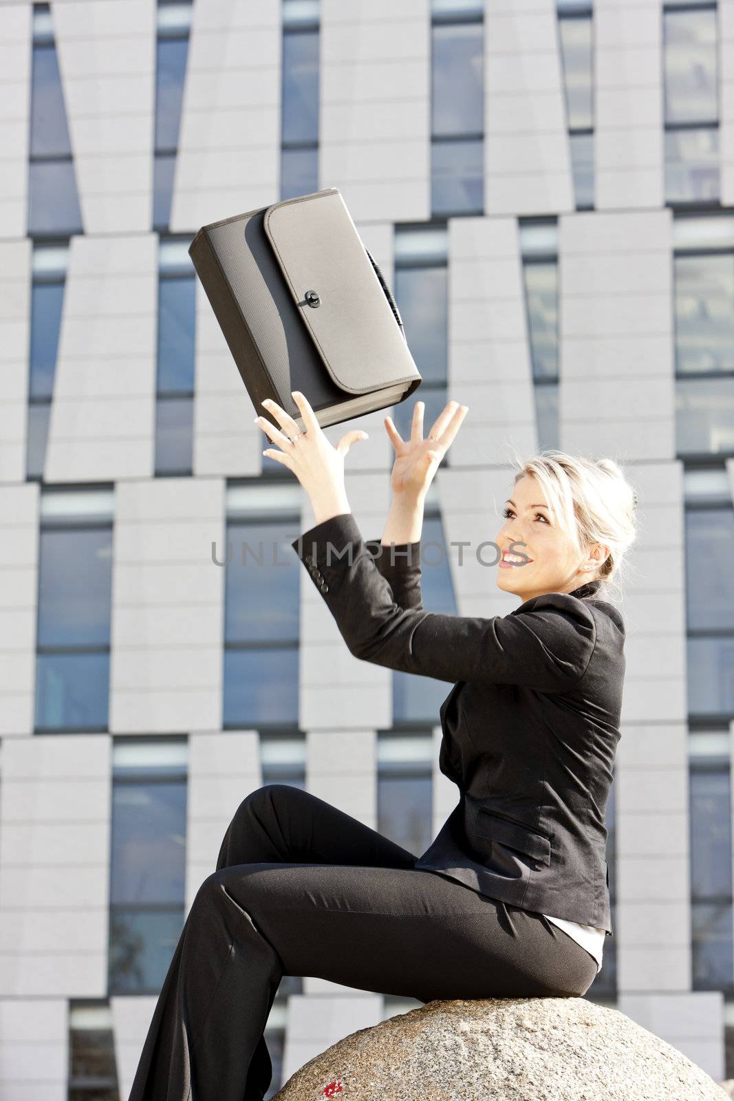 sitting young businesswoman with a briefcase by phbcz