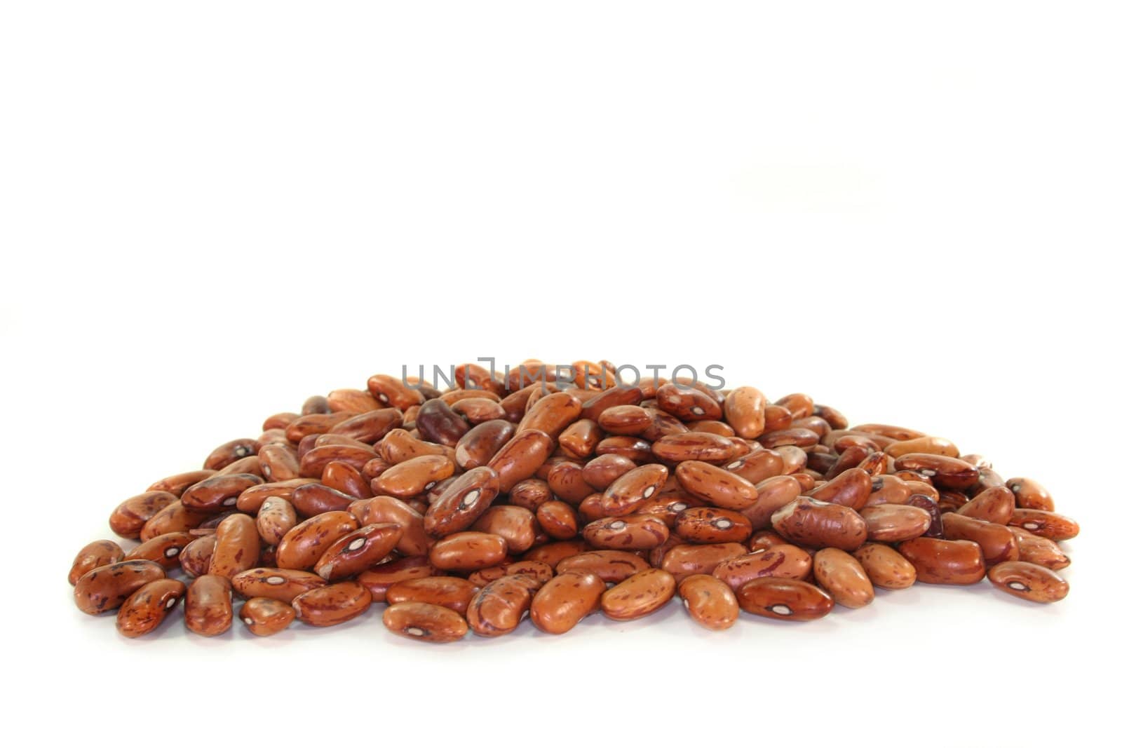 a handful of dried pinto beans on a white background
