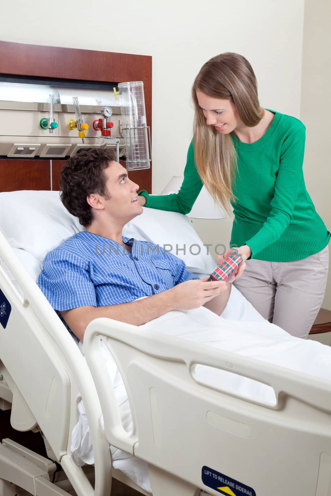 Young wife giving present to husband by leaf