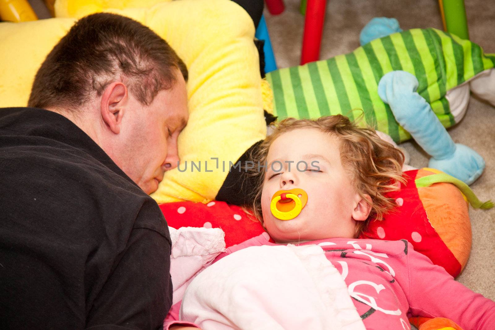 Father and daughter napping on the floor.