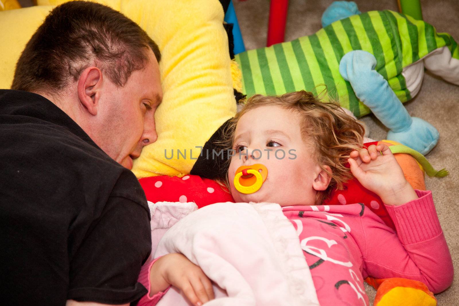 Father and daughter napping on the floor.