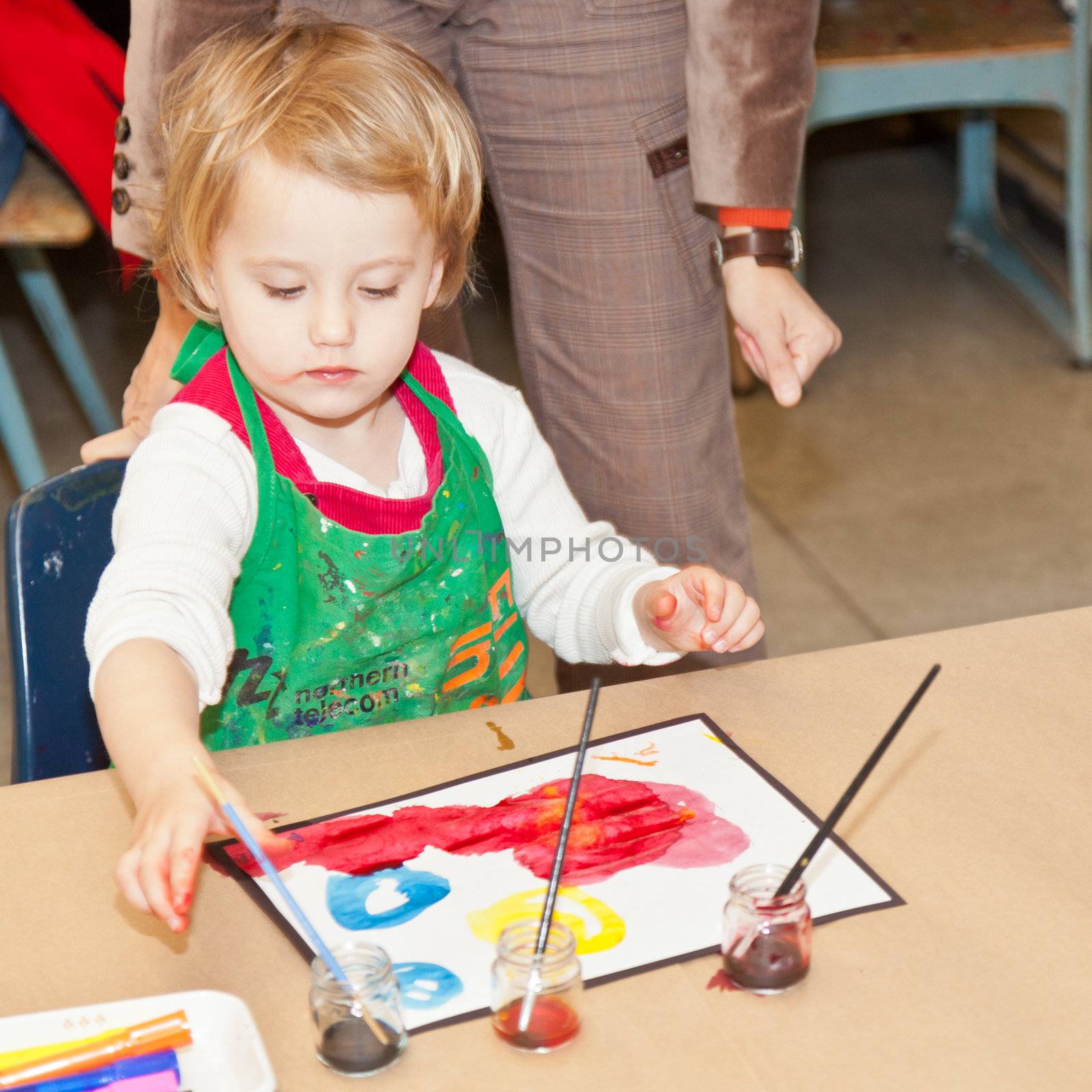 Cute little baby girl having fun painting at art class