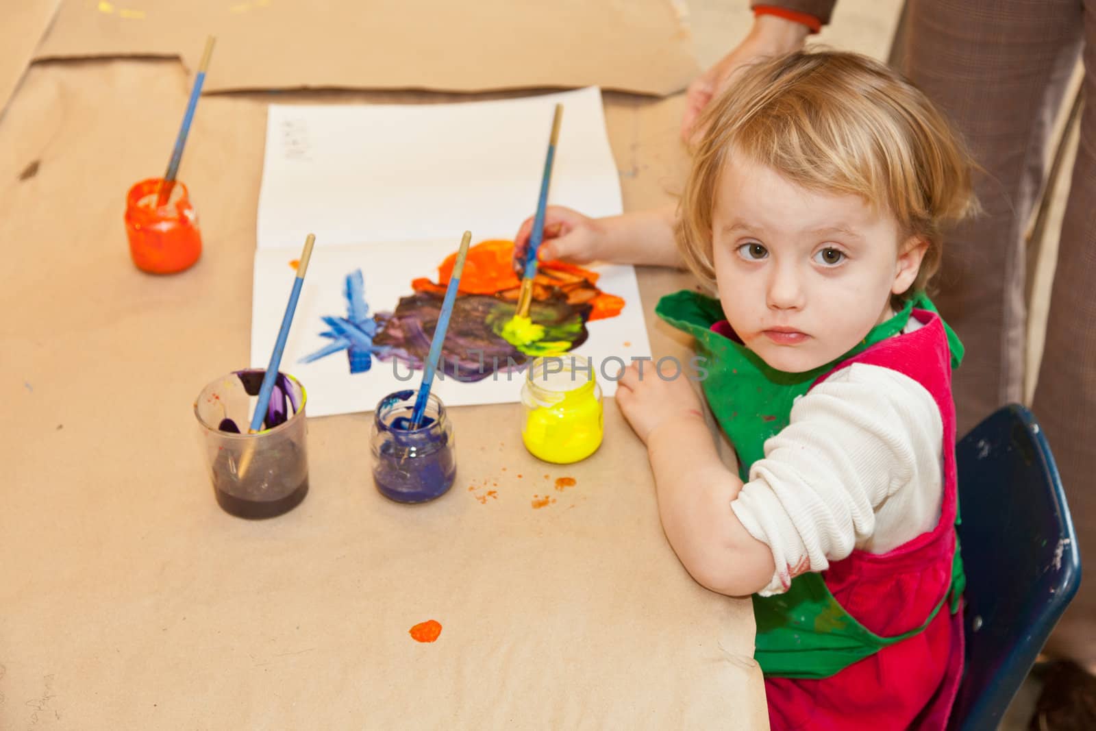 Cute little baby girl having fun painting at art class