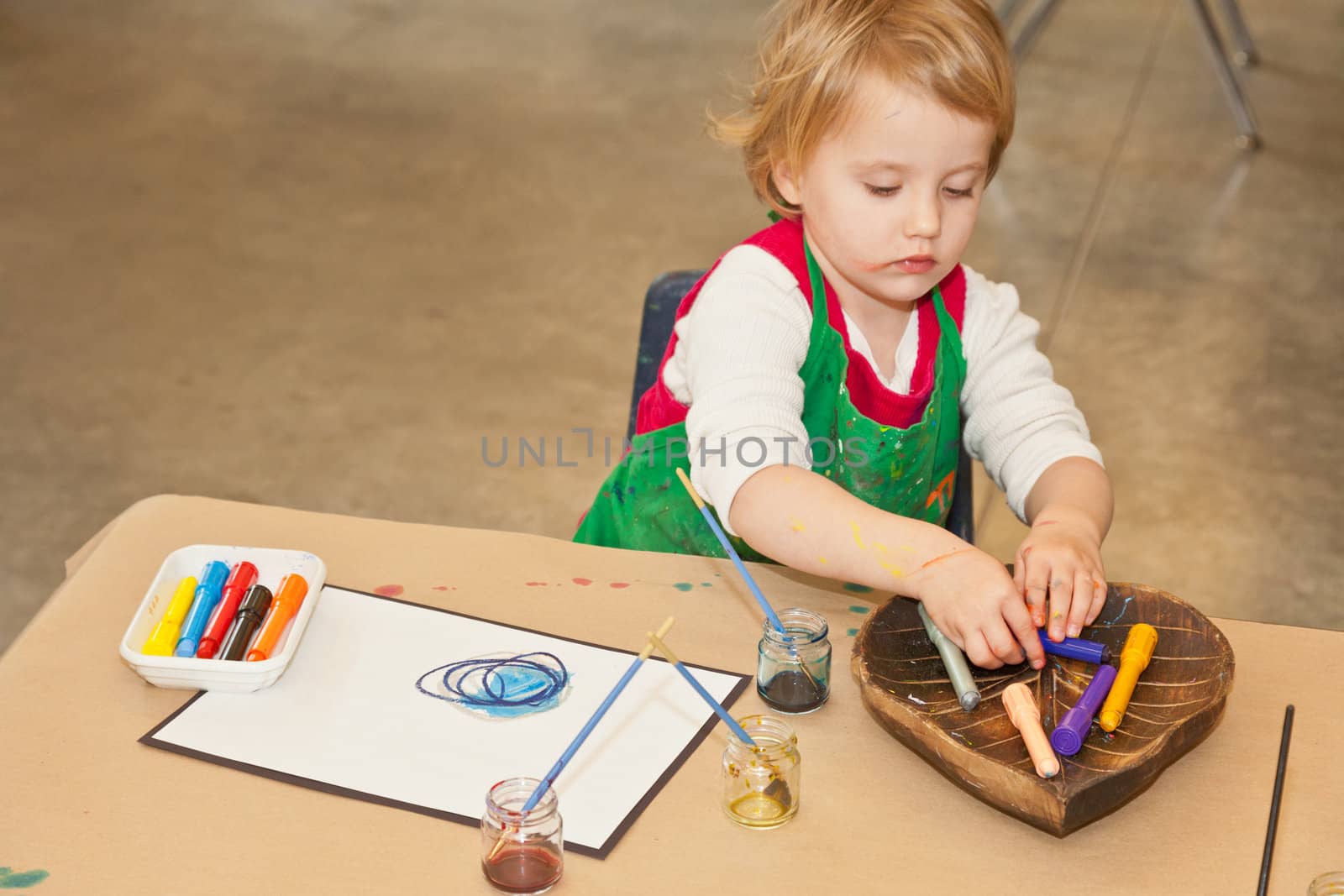 Cute little baby girl having fun painting at art class