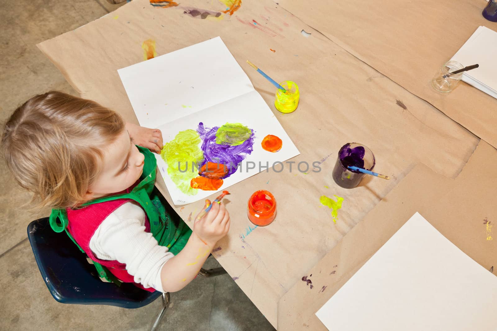 Cute little baby girl having fun painting at art class