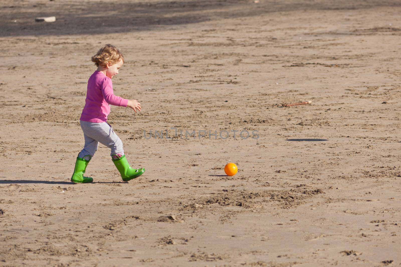 Cute little baby girl having fun on a beach