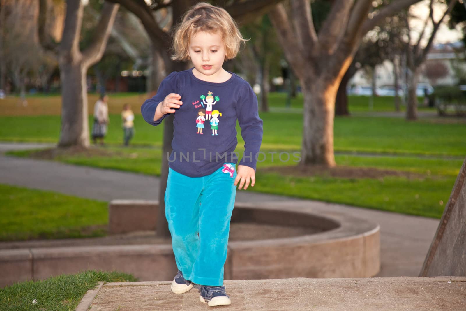 Cute little European girl having fun on playground in a park.