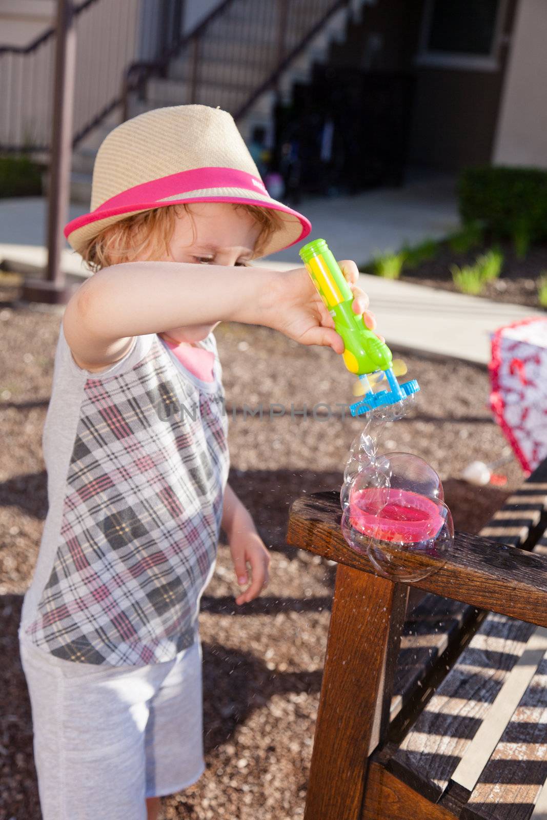 Having fun with bubble blowing machine on sunny day.