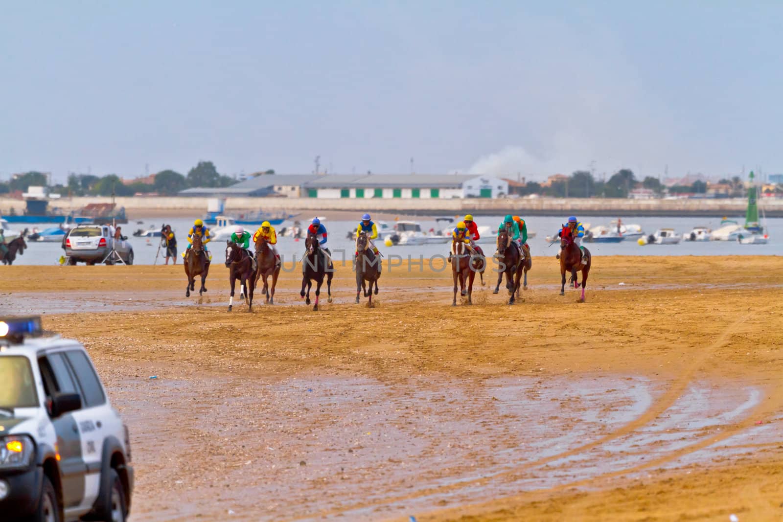 SANLUCAR DE BARRAMEDA, CADIZ, SPAIN - AUGUST 11: Unidentified riders race horses on Sanlucar de Barrameda beach on August 11, 2011 in Sanlucar de Barrameda, Cadiz, Spain.