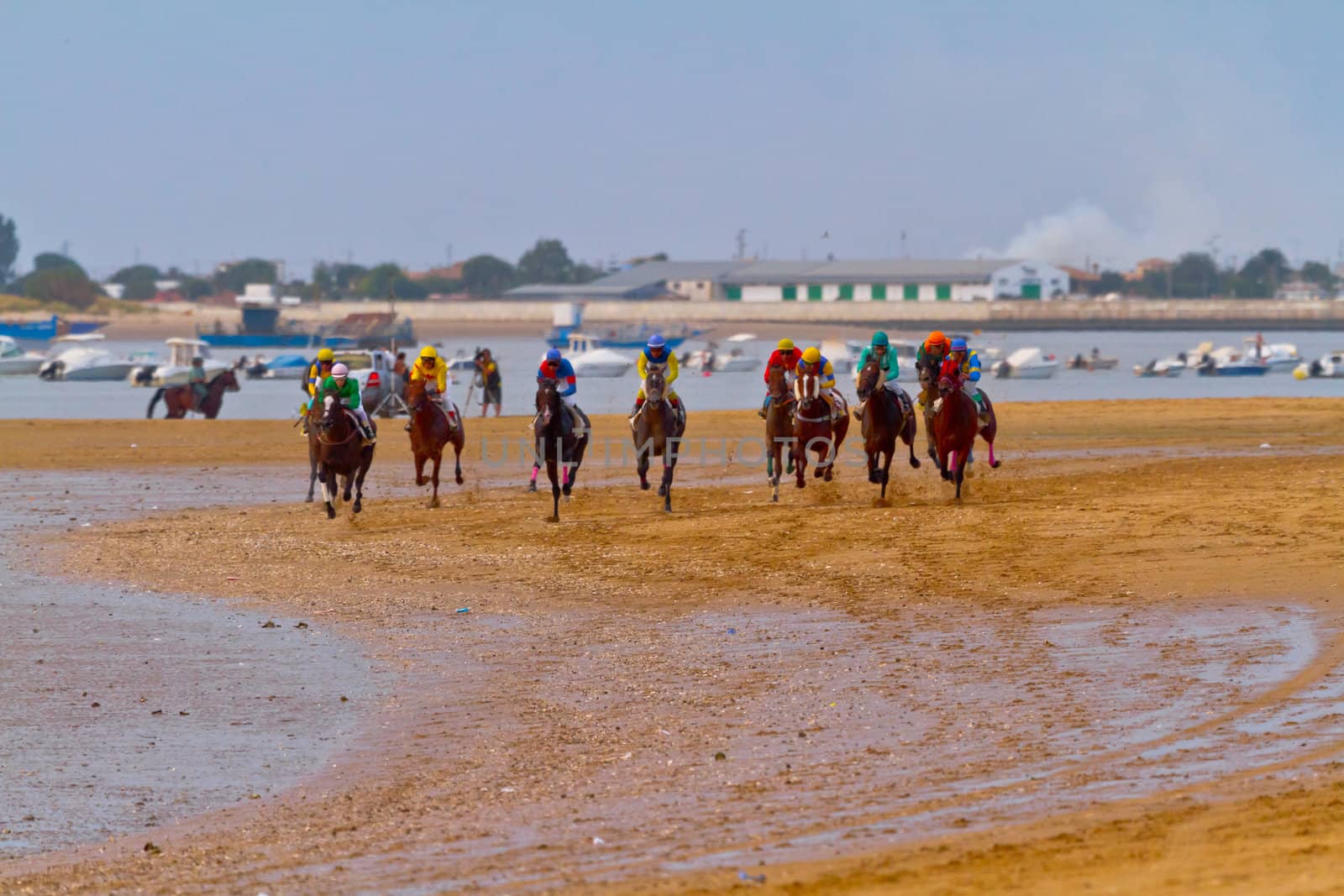 SANLUCAR DE BARRAMEDA, CADIZ, SPAIN - AUGUST 11: Unidentified riders race horses on Sanlucar de Barrameda beach on August 11, 2011 in Sanlucar de Barrameda, Cadiz, Spain.