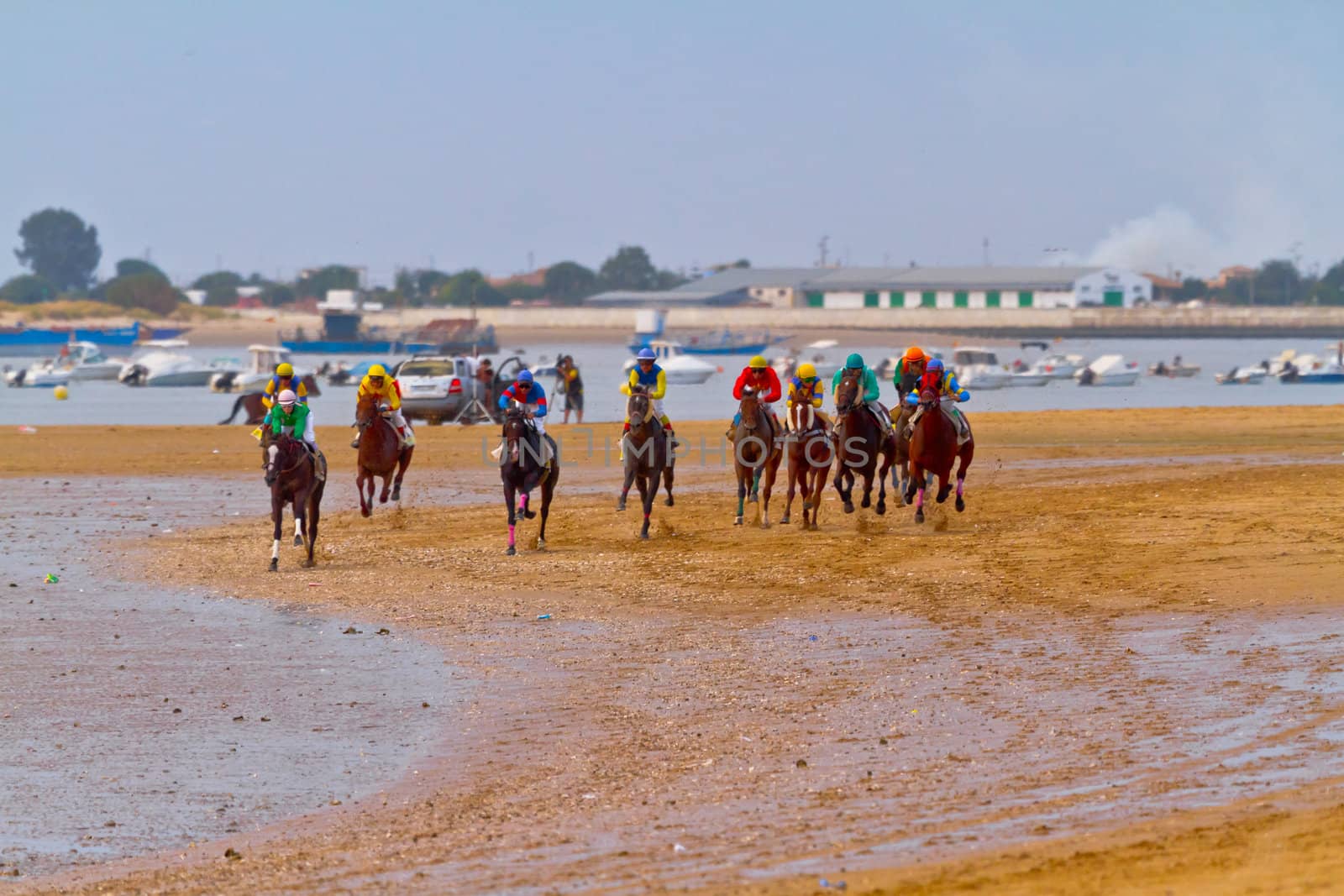 SANLUCAR DE BARRAMEDA, CADIZ, SPAIN - AUGUST 11: Unidentified riders race horses on Sanlucar de Barrameda beach on August 11, 2011 in Sanlucar de Barrameda, Cadiz, Spain.